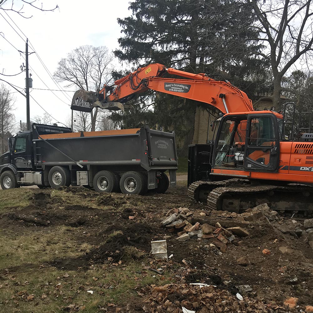 Excavating demolition site, loading into dump truck